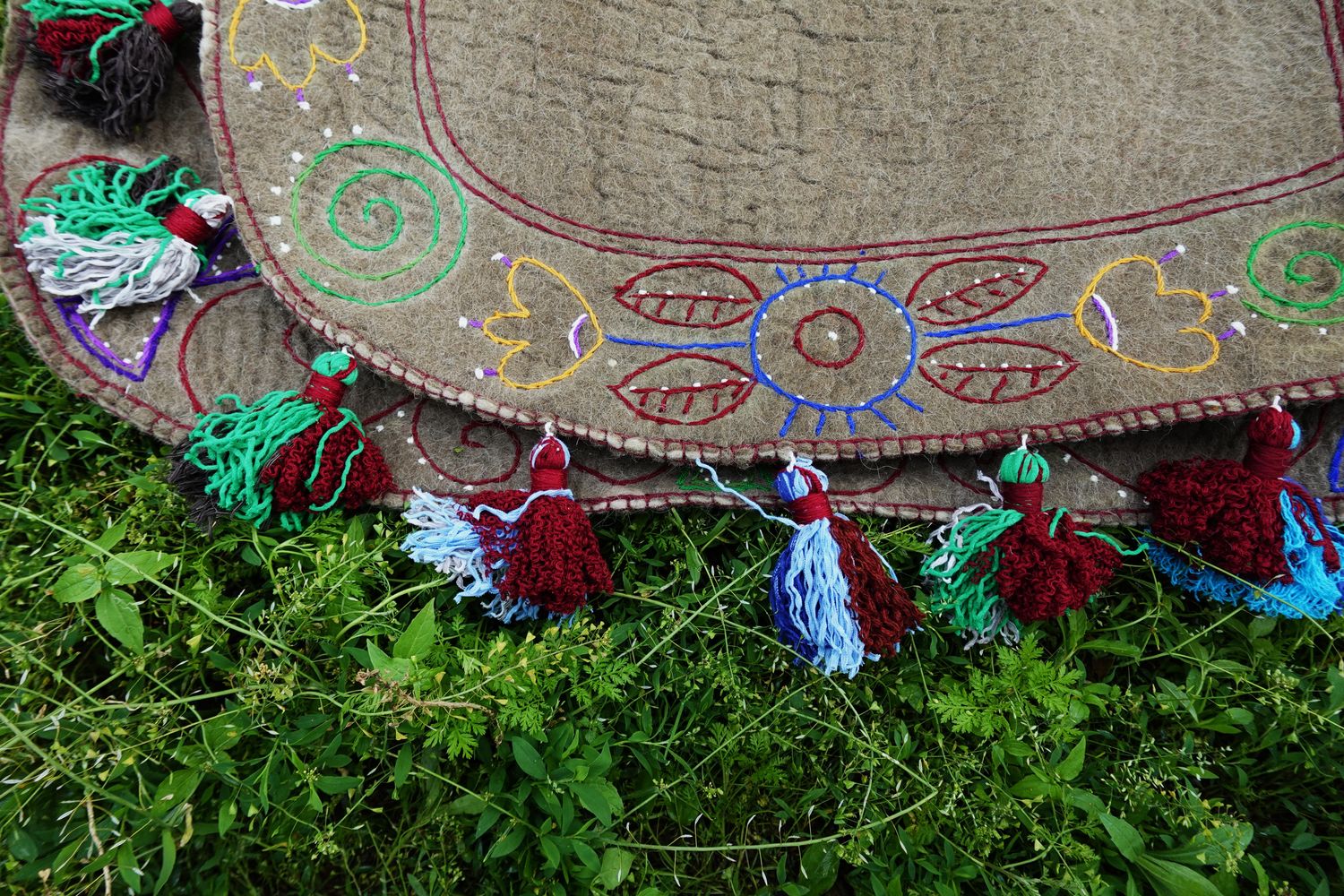 Close view of tassels and floral embroidery on a felt Shabrak