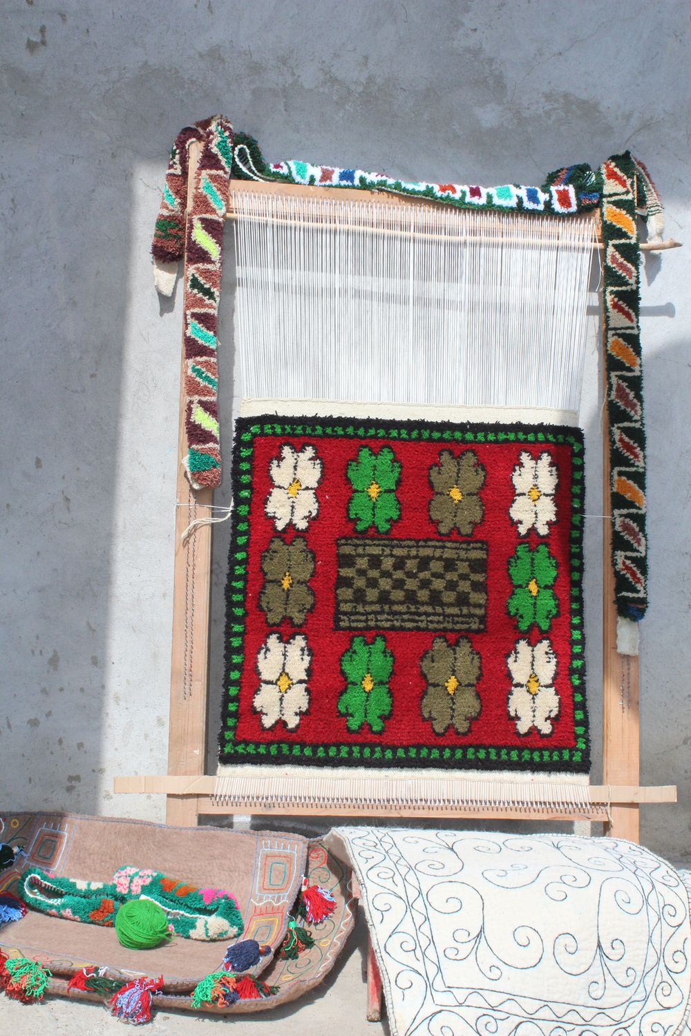 Loom with a finished red Shabrak panel and a decorated border