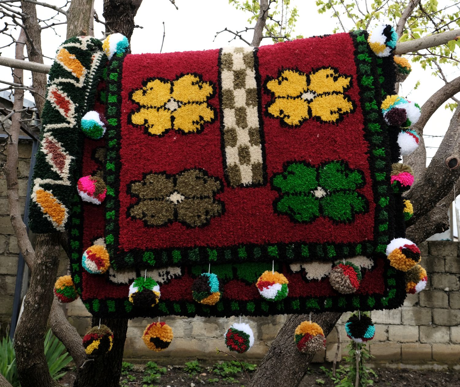 Red woven Shabrak hanging in a tree, gold flowers and checked panel