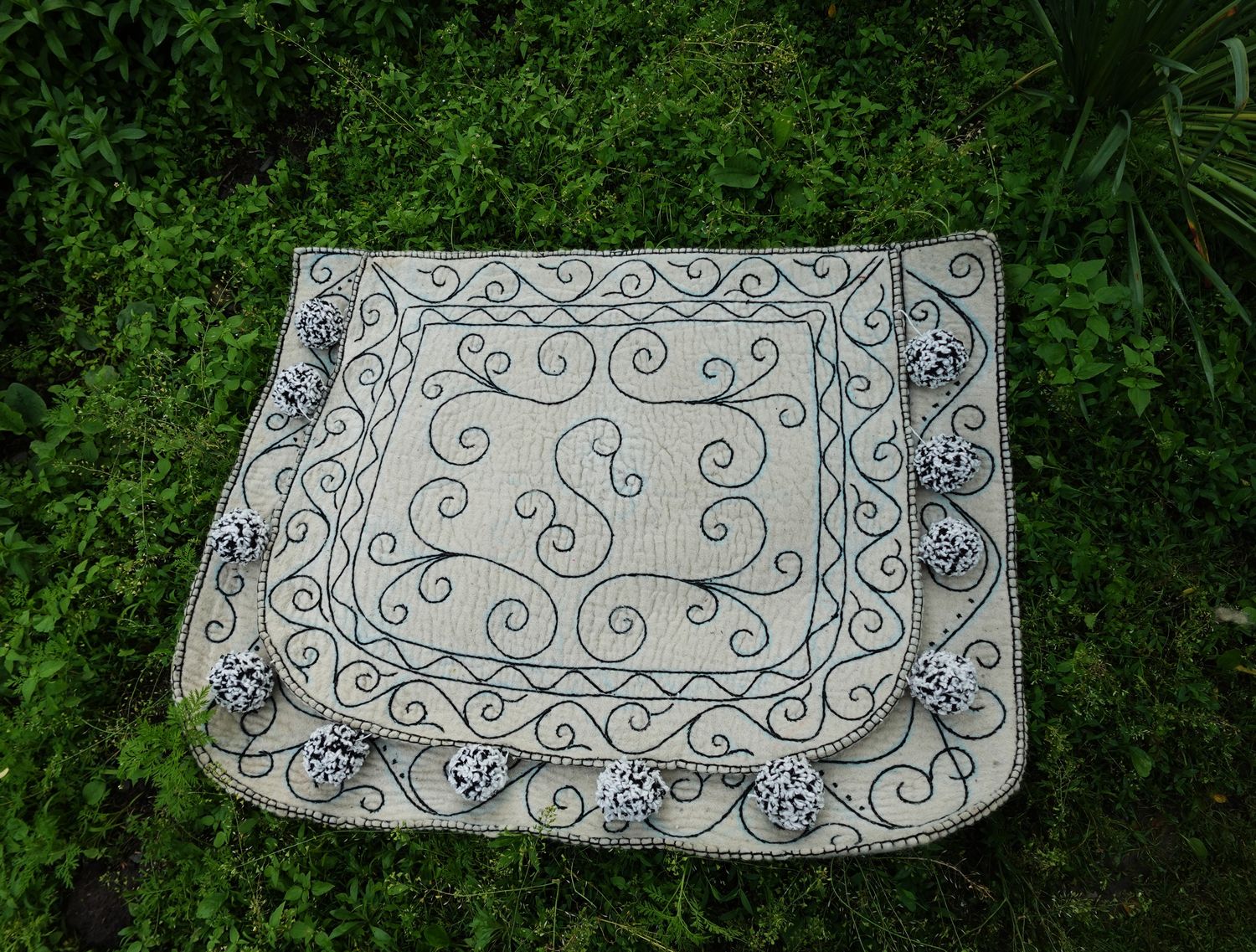 White felt Shabrak with blue scroll embroidery on grass